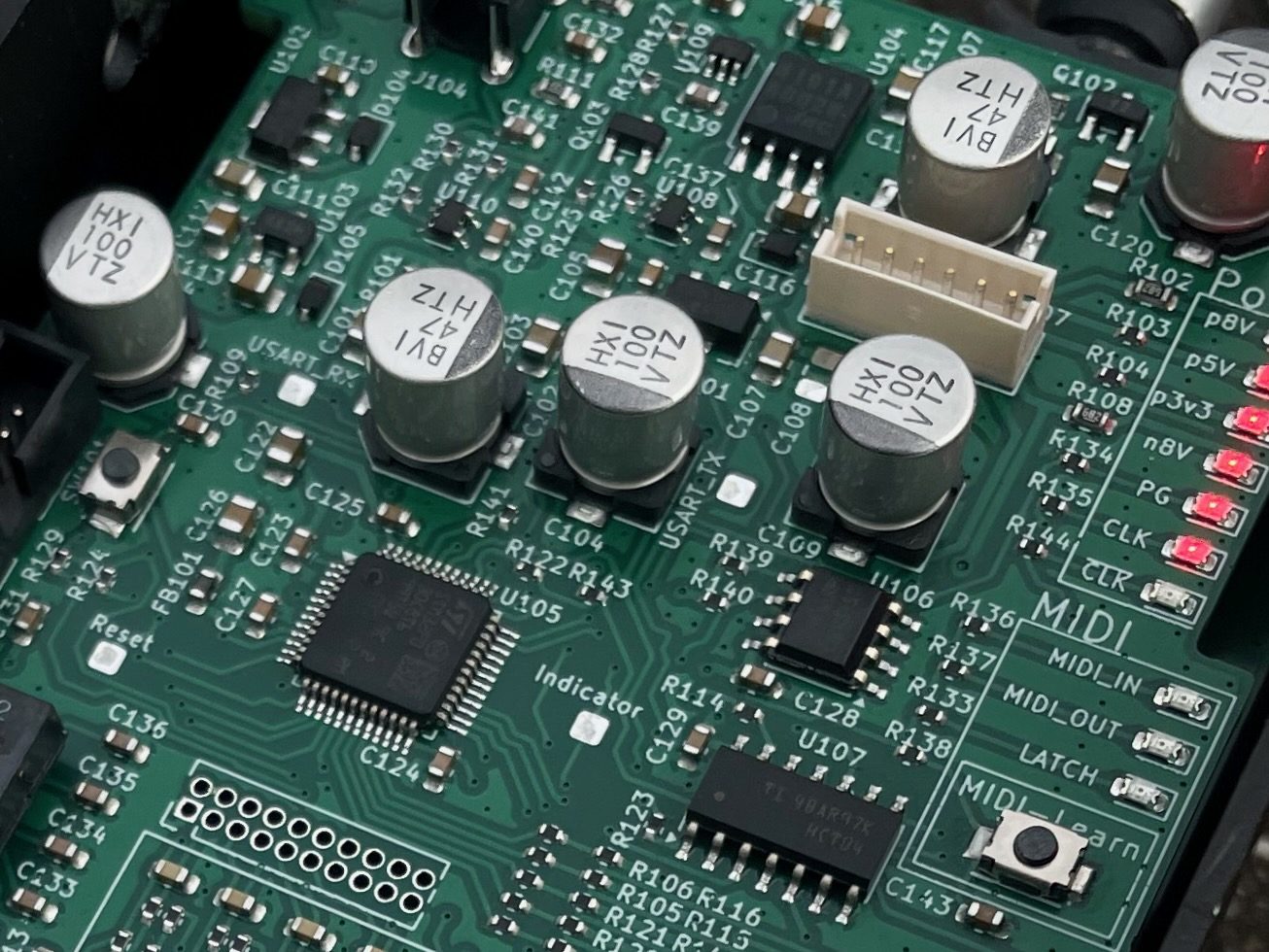 デジタル部基板の接写。右側に MIDI IN / MIDI OUT / LATCH のシルクと MIDI-Learn のボタン、左下に制御用のマイコン、右端に電源レールの LED が並ぶ